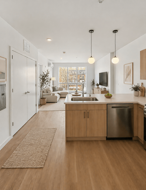 A modern kitchen with wooden floors and a stainless steel dishwasher.