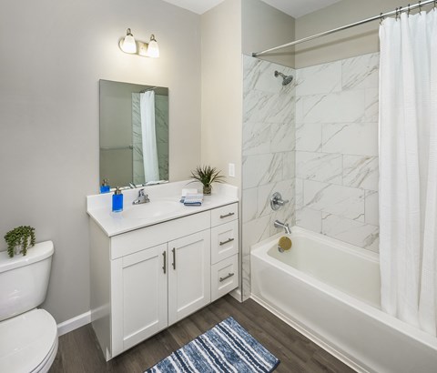 a bathroom with a sink toilet and shower and a bath tub at Eden & Main 55+ Apartments, Southington , CT