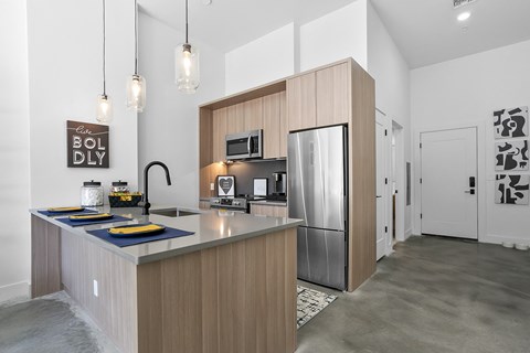 a kitchen with a large island and a stainless steel refrigerator
