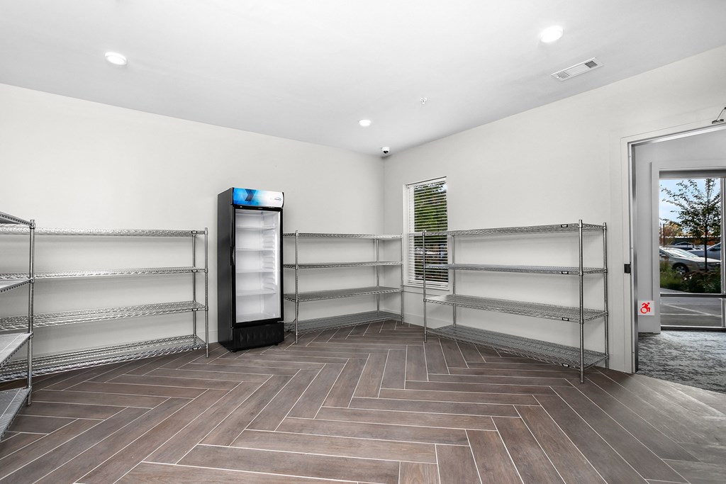 Empty store interior with a refrigerator on the left.