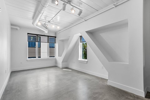 an empty room with white walls and a window