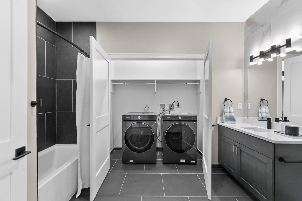 A black and white bathroom with a double washing machine.