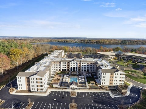 A large white building with a pool in the middle of a parking lot.
