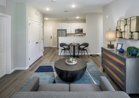 a living room with a couch and a coffee table in front of a kitchen at Eden & Main 55+ Apartments, Connecticut, 06489