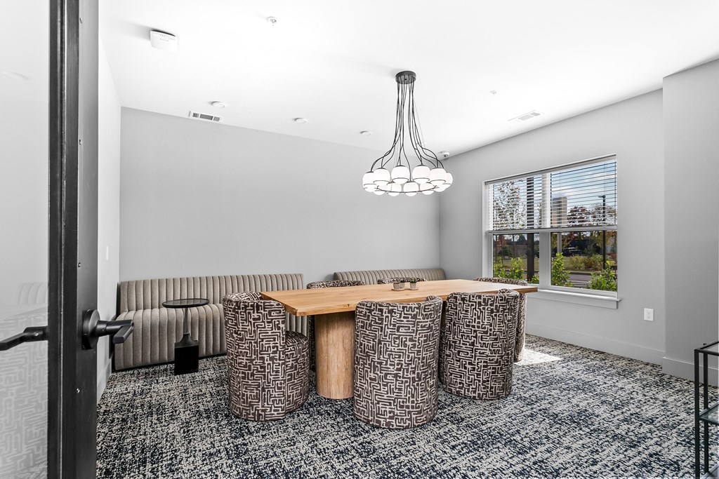 A room with a grey carpet and a brown table.