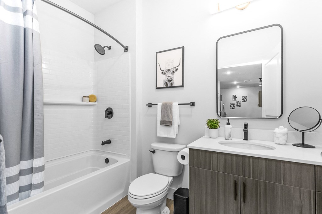 A bathroom with a white tub, toilet, and sink.