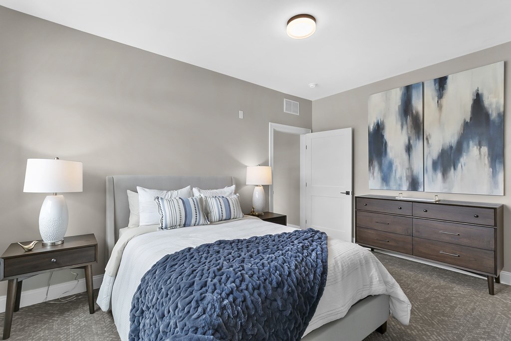 A bedroom with a large bed and a painting on the wall.