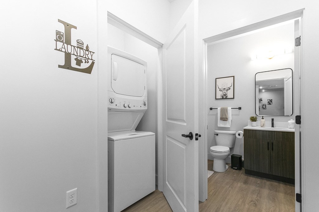 A laundry sign is on the wall above a washer and dryer.