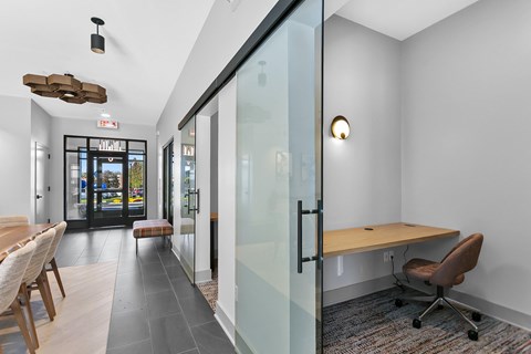 A conference room with a glass wall and a wooden table.