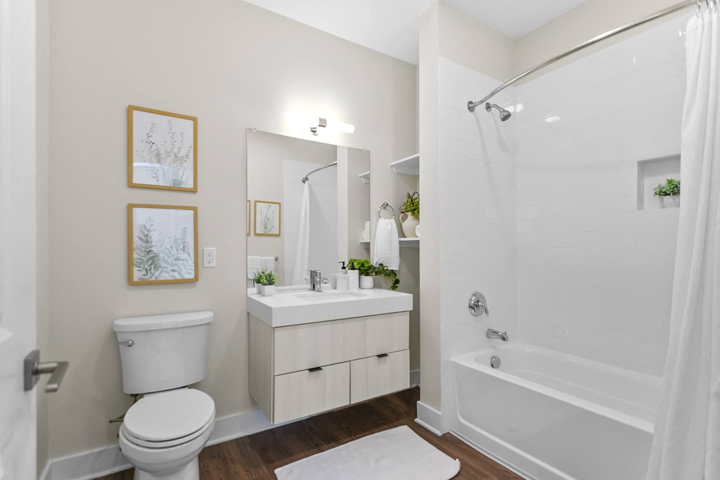 A white bathroom with a toilet, sink, and bathtub.
