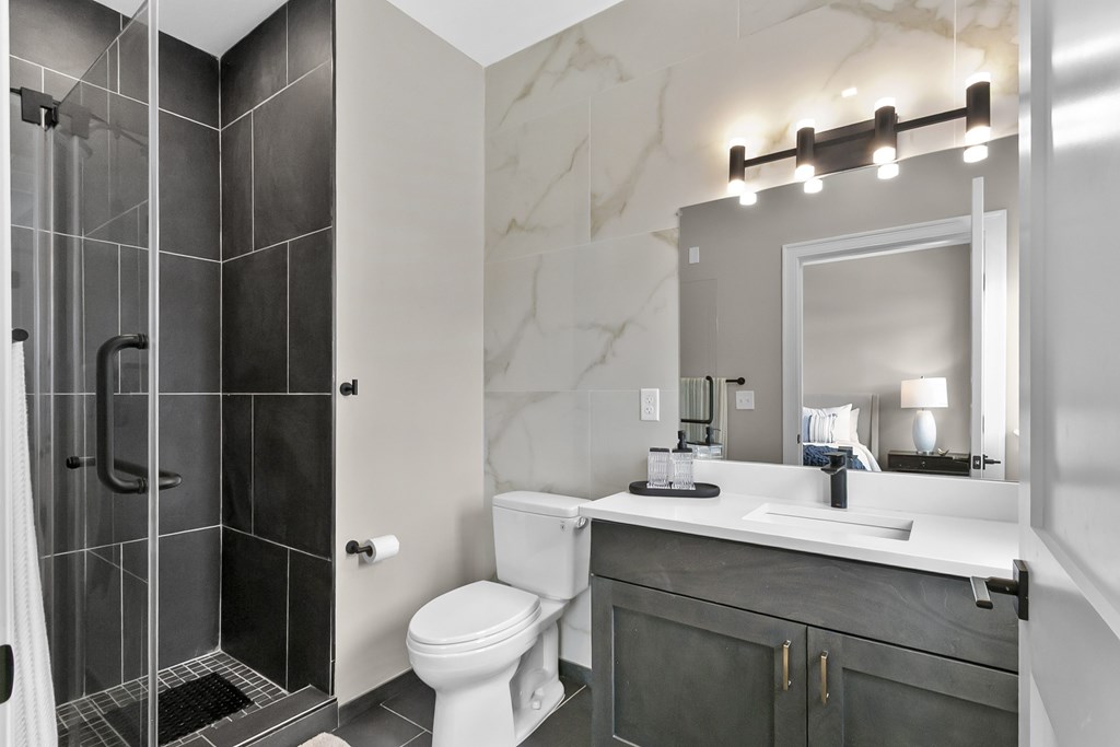 A bathroom with a toilet, sink, and shower.