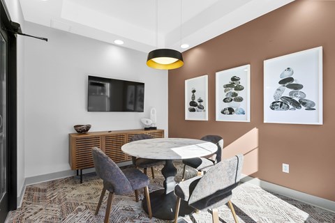 A dining room with a table and chairs.