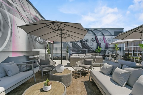 a rendering of a rooftop patio with umbrellas and couches
