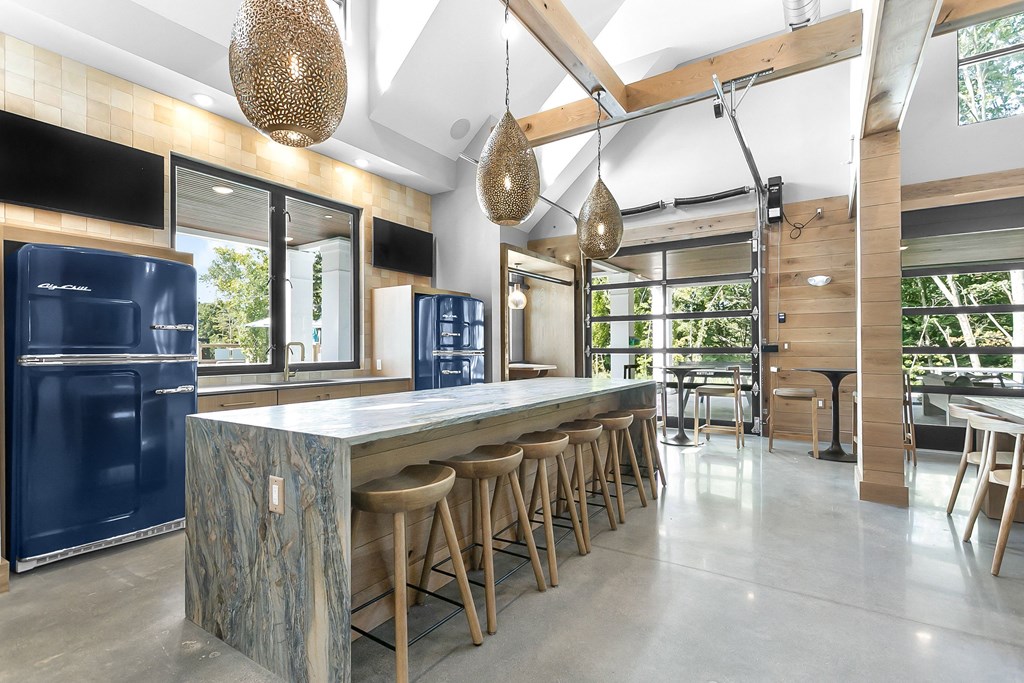 A kitchen with a blue fridge and wooden bar stools.