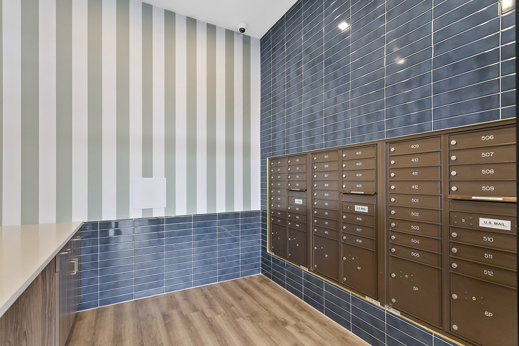 A wall of mailboxes are on the right side of a hallway.