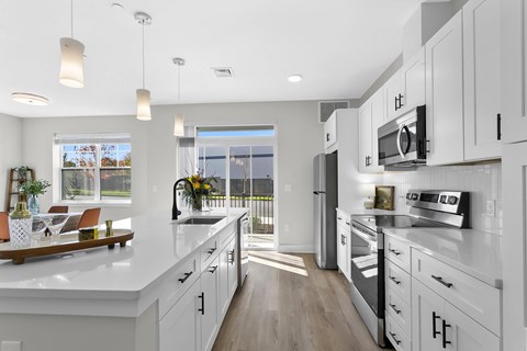 A modern kitchen with white cabinets and a large island.