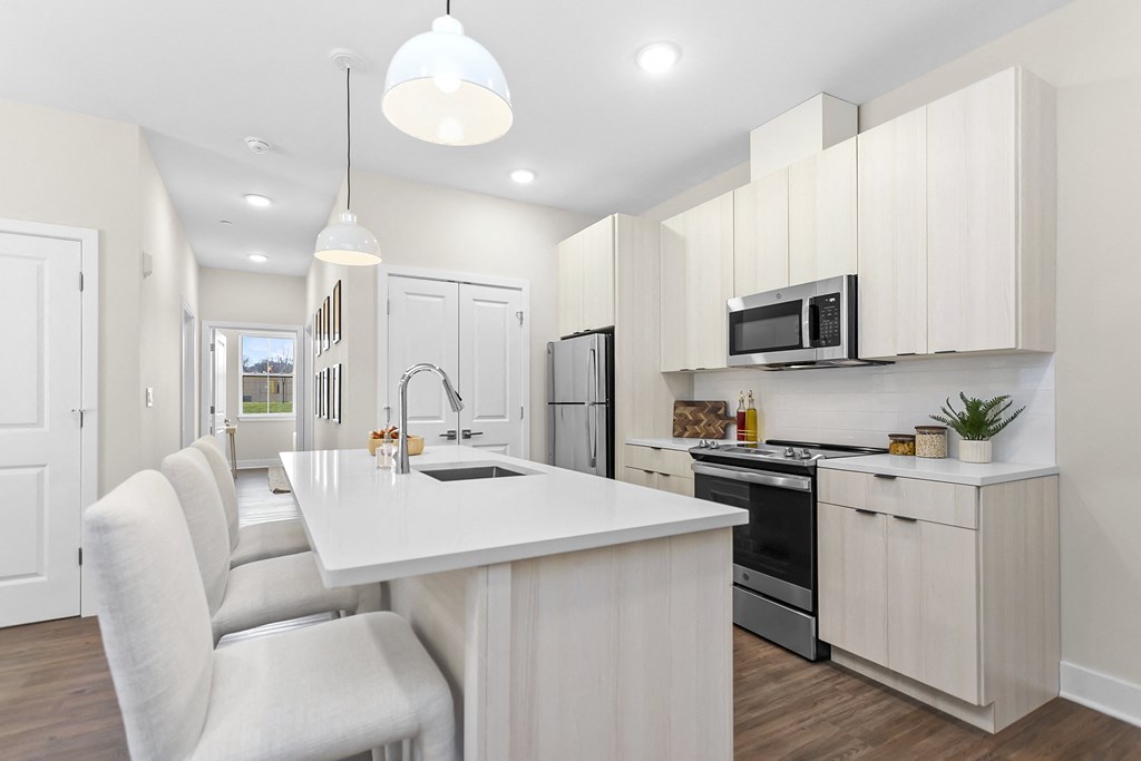 A modern kitchen with white cabinets and appliances.