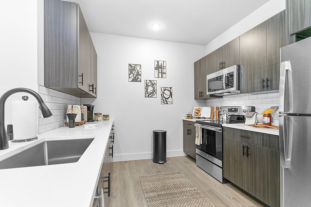 A modern kitchen with a white sink and a refrigerator.
