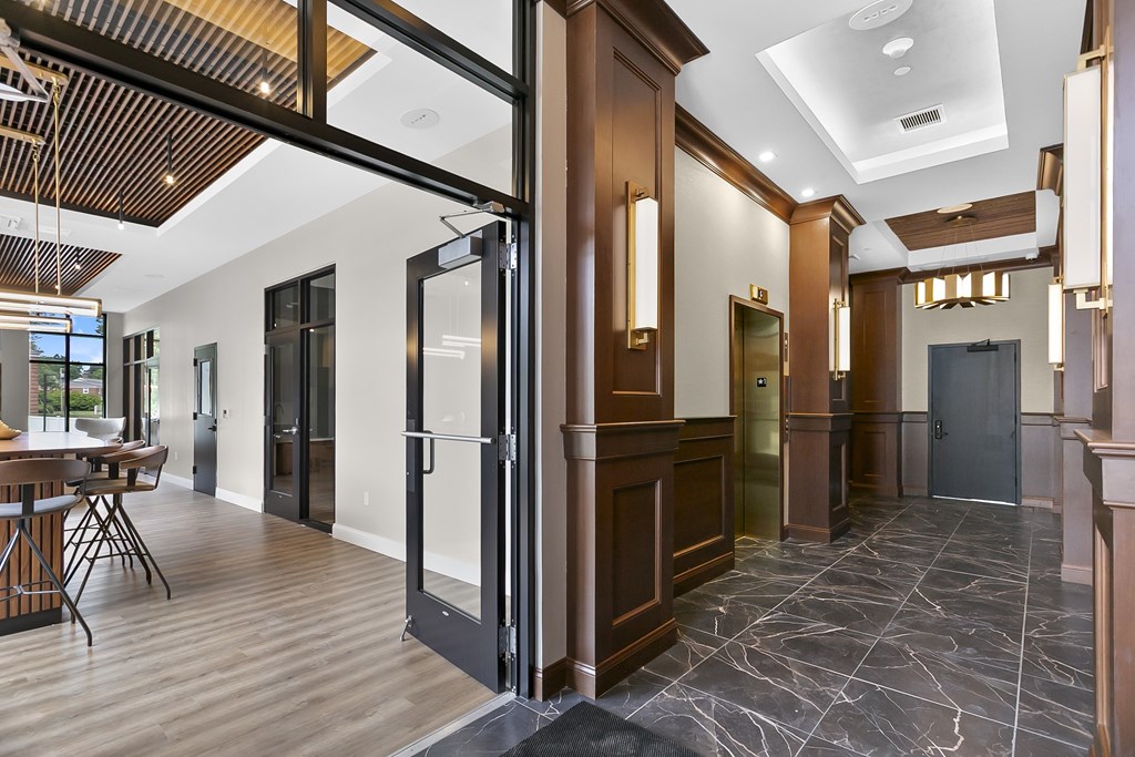 A hallway with a wooden floor and a glass door.