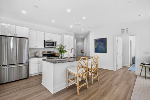 A kitchen with white cabinets and a wooden island.