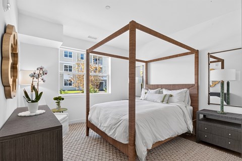 A bedroom with a large bed and a wooden headboard.