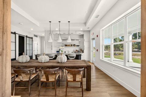 A dining room with a wooden table and chairs.