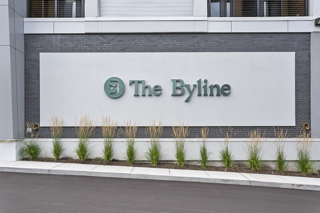 The sign of The Byline is displayed on a building.