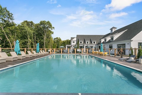 A large outdoor swimming pool with lounge chairs and umbrellas.