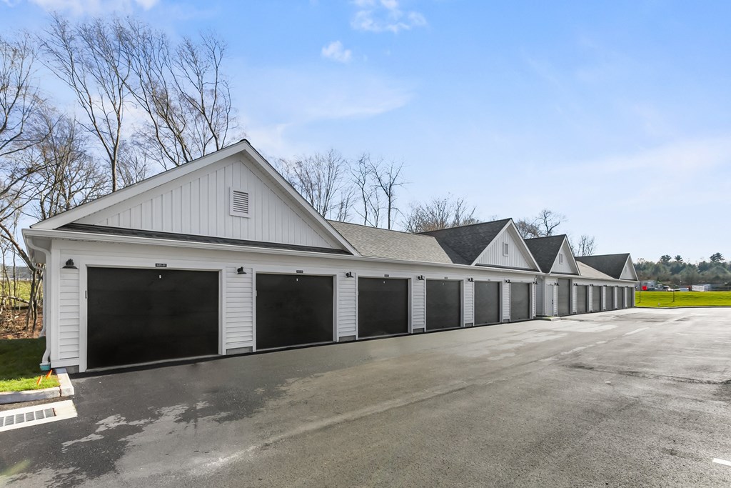 A long white building with black garage doors.