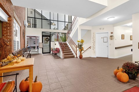 the living room with pumpkins on the floor and a staircase
