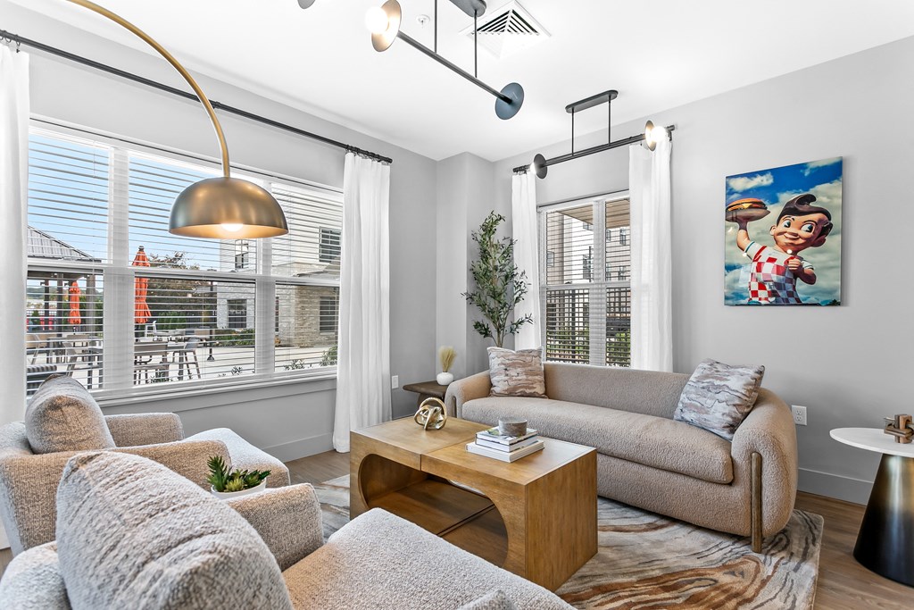 A living room with a grey couch, a wooden coffee table, and a painting of a boy on the wall.