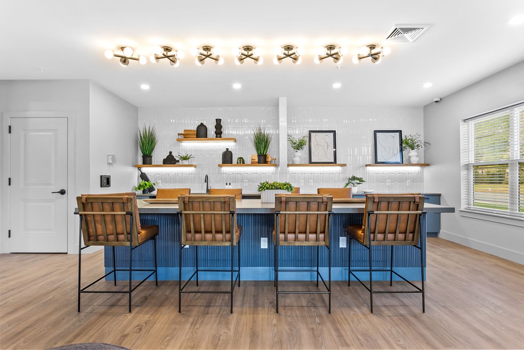 A kitchen with a blue bar and wooden chairs.