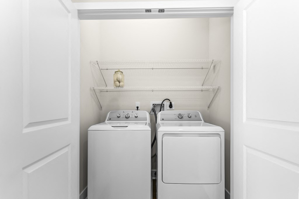 A white laundry room with a washer and dryer.