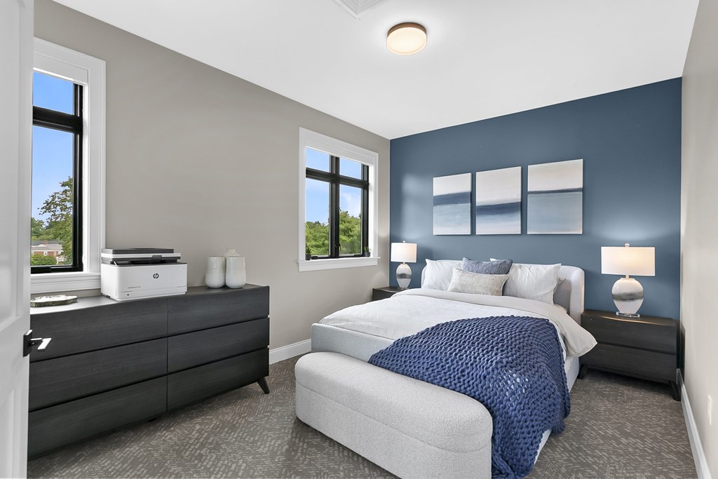 A bedroom with a bed, nightstands, and a window.