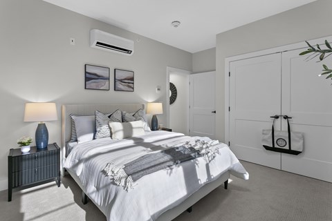 A bedroom with a large bed and a white wall.