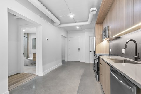 a kitchen with a sink and a stove and a door to a bathroom