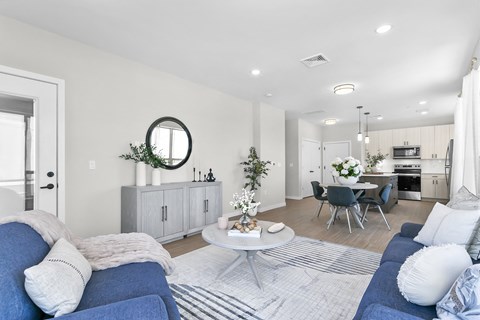 A modern living room with a blue sofa and a white coffee table.