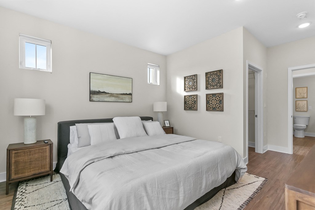 A bedroom with a large bed and a painting on the wall.