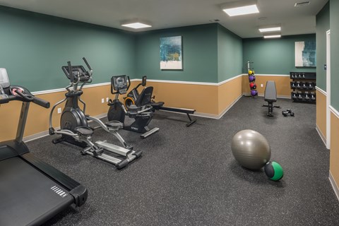 a gym with exercise equipment and a ball on the floor at Eden & Main 55+ Apartments, Southington , Connecticut