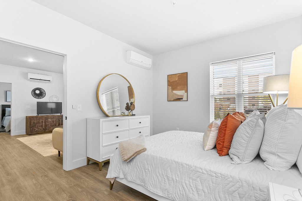 A bedroom with a bed, dresser, and mirror.