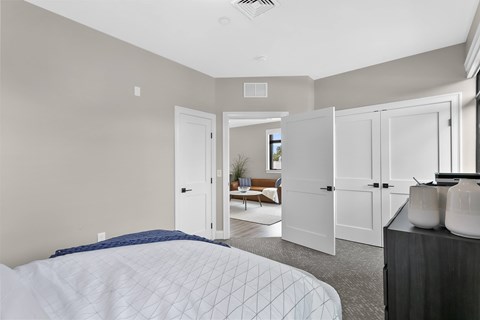 A bedroom with a large bed and a couch in the background.