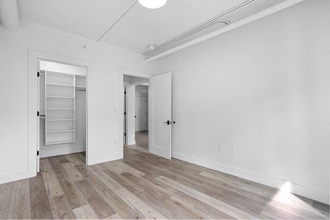an empty living room with white walls and wood flooring