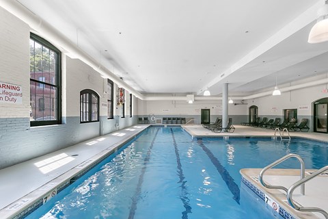 a swimming pool in a building with a blue water floor and at Clocktower and Velvet Mill Apartments, Connecticut
