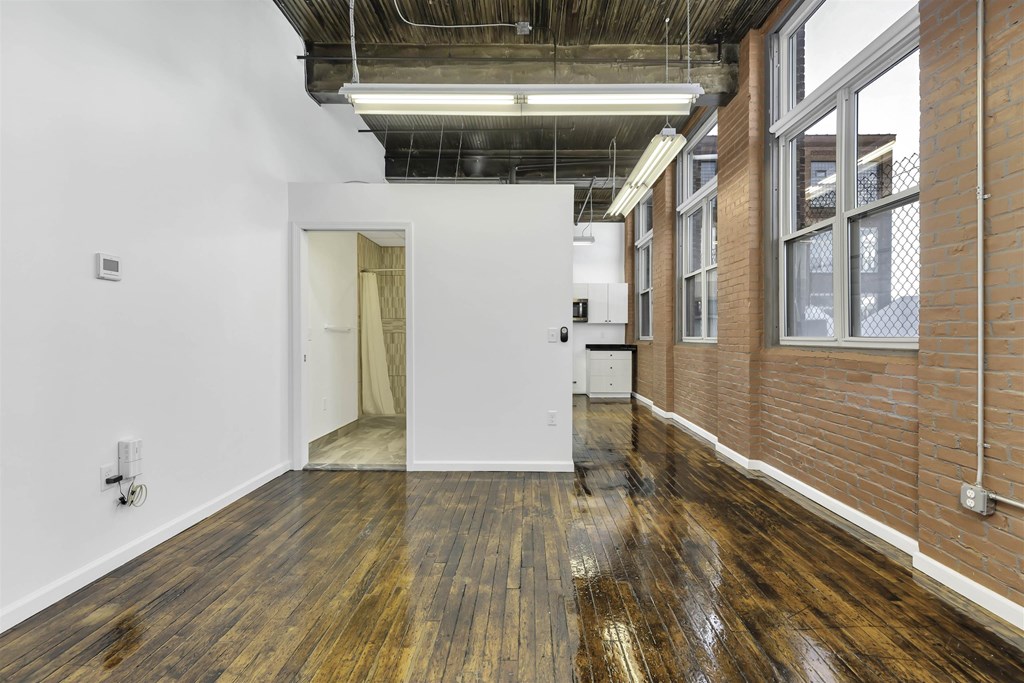A room with wooden floors and a white wall.