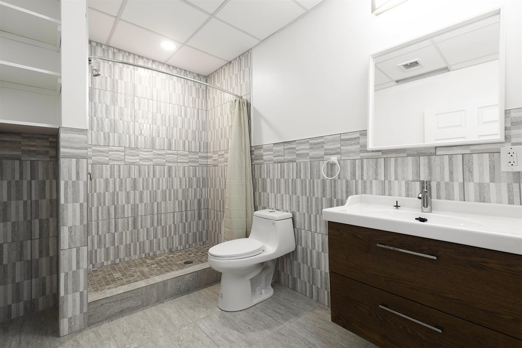 A white toilet is in a bathroom with a shower curtain.