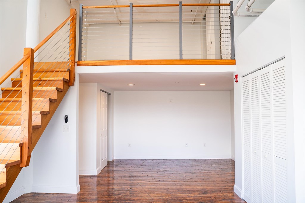 A room with a wooden staircase and white walls.