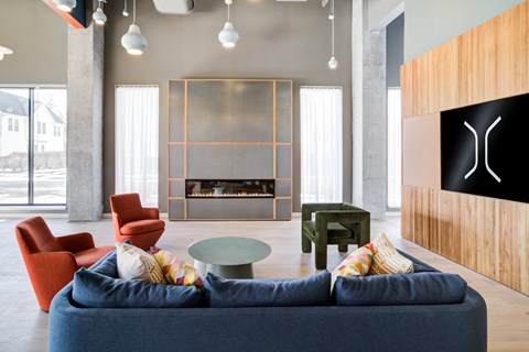 A living room with a blue couch and a fireplace.