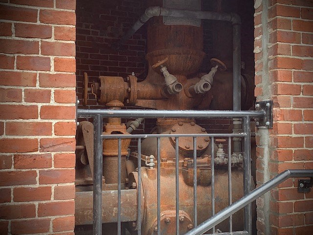 an old fire hydrant is behind a metal gate