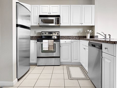 A kitchen with white cabinets and appliances.