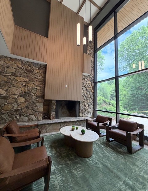 A living room with a stone fireplace and a stone wall.